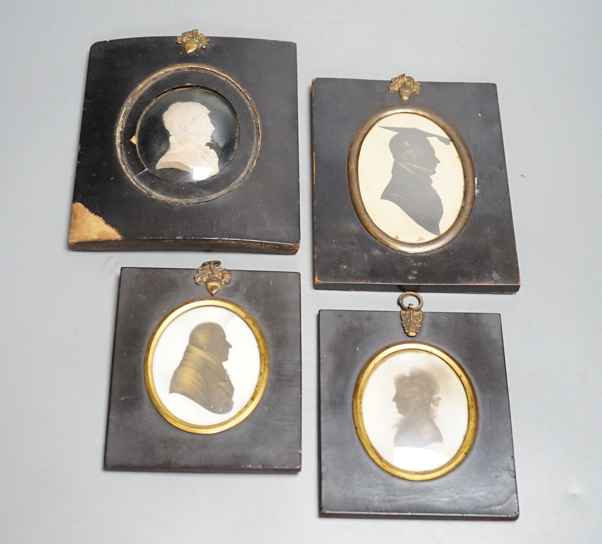 A plaster head relief and three silhouettes